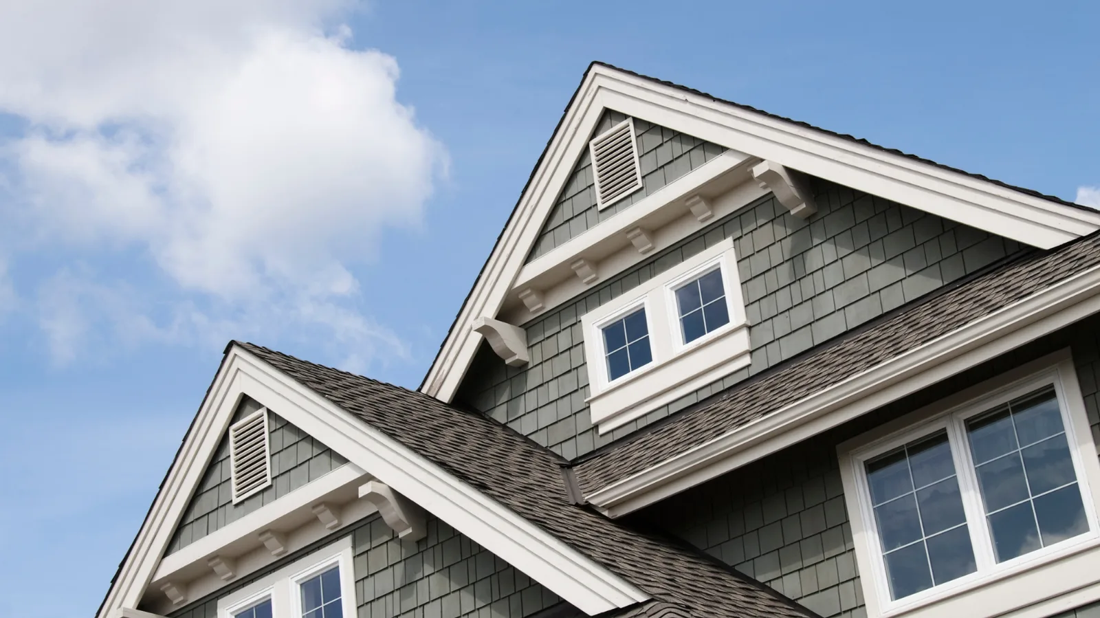 House gables with white trim above a brown shingle roof